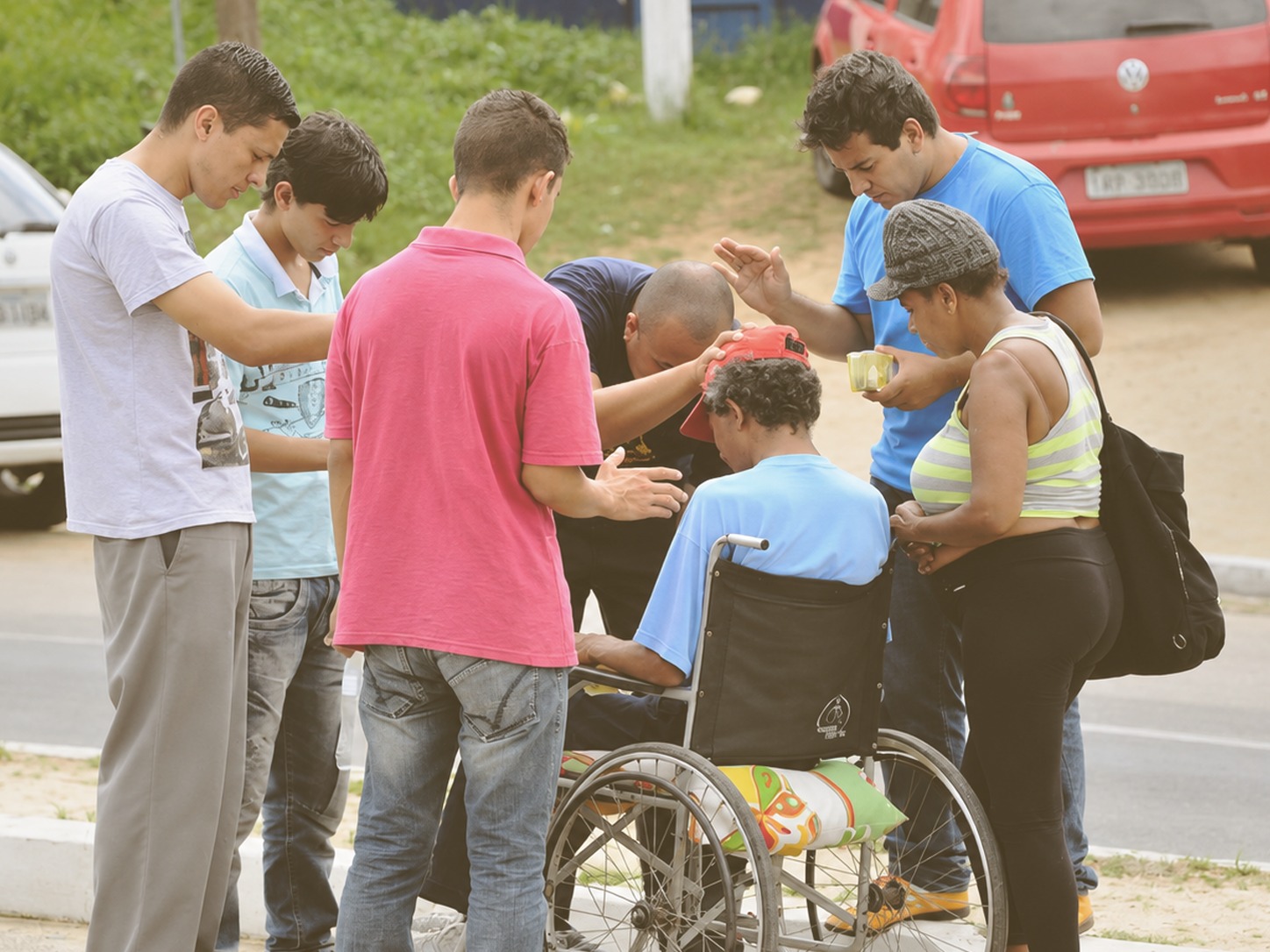 Pessoas servindo e orando por alguém, imagem ilustrativa